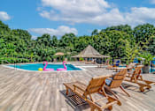 Thumbnail 10 of 12 - Affinitee at Pine Lake Apartments in Pine Lake, GA photo of a swimming pool with deck chairs around it
