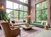 Thumbnail 8 of 12 - Affinitee at Pine Lake apartment a living room with large windows and a green couch