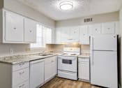 Thumbnail 5 of 12 - Affinitee at Pine Lake apartment a white kitchen with white appliances and white cabinets